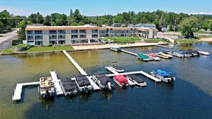 A marina with several docked boats, a building with a modern design, and a clear view of the surrounding greenery.