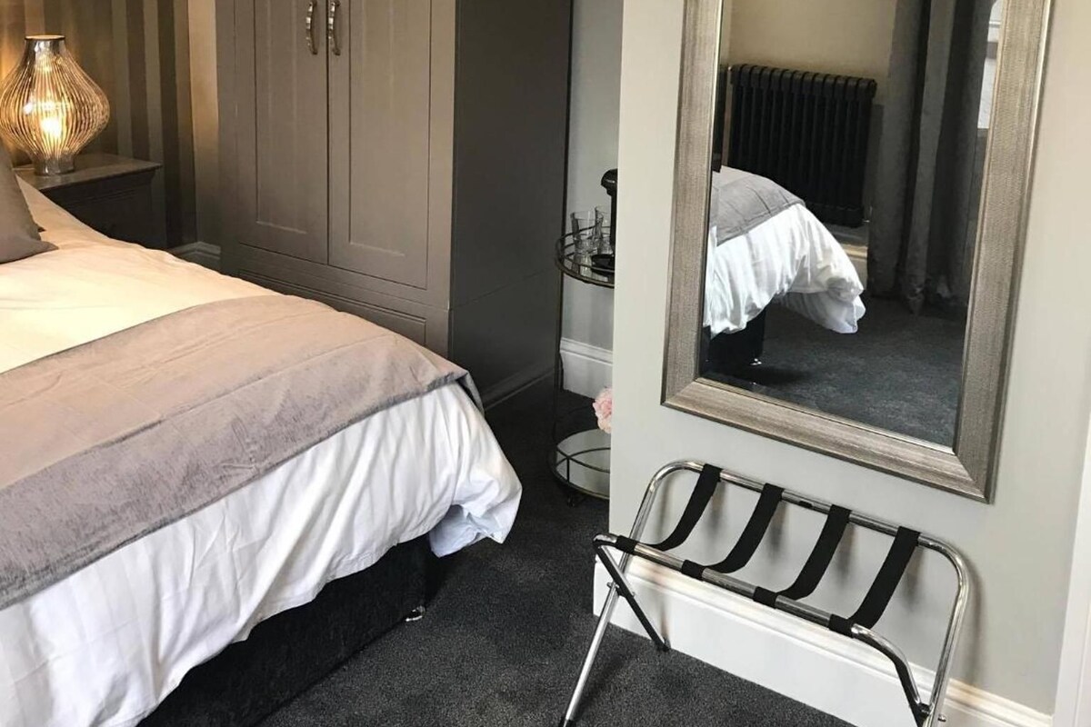 Una camera da letto con un letto, un armadio, uno specchio e un termosifone.