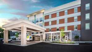 A modern hotel with a covered entrance, multiple floors, and a parking area. - Tru by Hilton Minneapolis Mall of America (Bloomington)