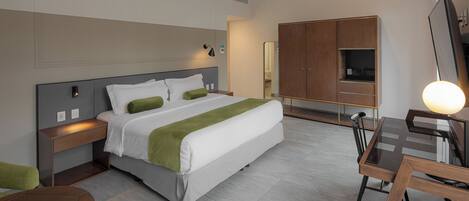 Una habitación de hotel moderna con cama, mesitas de noche, escritorio y silla.