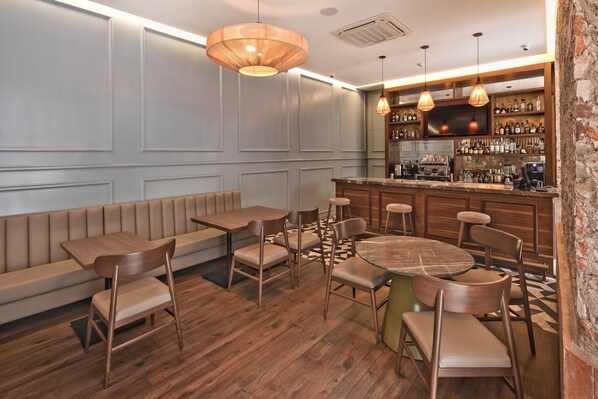A restaurant interior with wooden tables and chairs, a bar area, and a seating section with a bench.