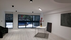 A spacious room with large windows, a marble-topped table, and a modern art piece on the wall. - The Link Athens (Athens)
