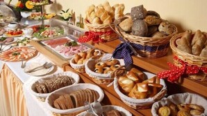 A buffet table with various food items including bread, pastries, and meats. - Holiday Home Tatralandia (Liptovsky Mikulas)
