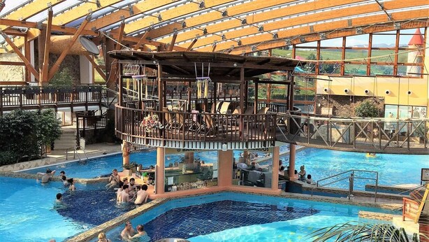 An indoor swimming pool with multiple levels and a covered area with seating. - Holiday Home Tatralandia (Liptovsky Mikulas)