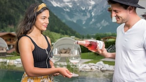 A man and a woman by a pool with mountains in the background. - Adults only Boutique - Hotel Unterlechner (Sankt Jakob in Haus)