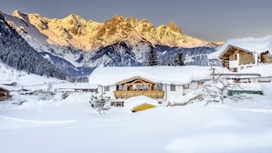 A snow-covered mountain lodge with a wooden exterior, a balcony, and a view of the surrounding mountains. - Adults only Boutique - Hotel Unterlechner (Sankt Jakob in Haus)