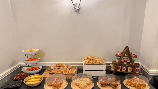 A buffet table with various food items including fruits, pastries, and yogurt. - Consort Hotel & Urban Spa (Rotherham)