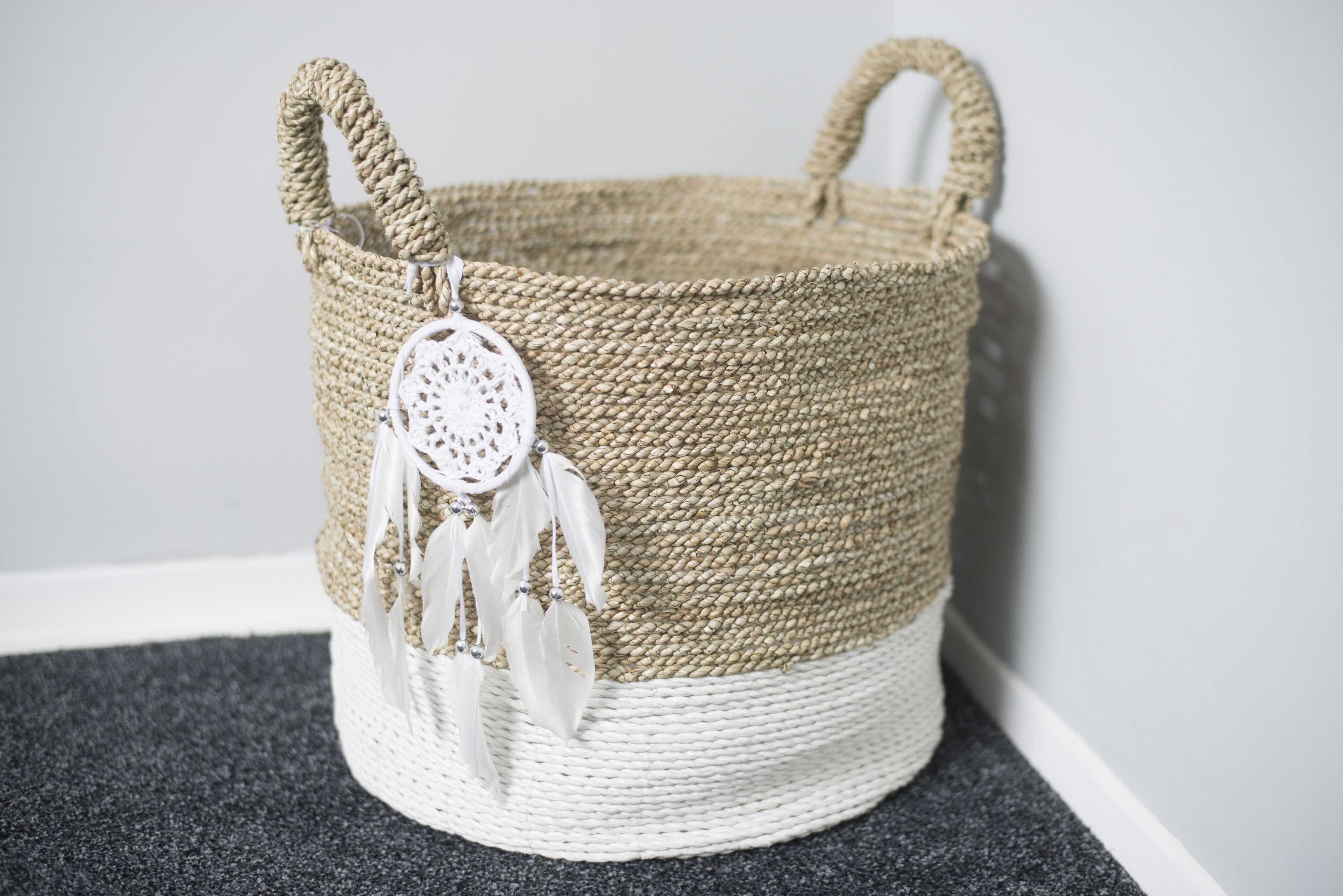 A woven basket with a handle and a decorative white tag.