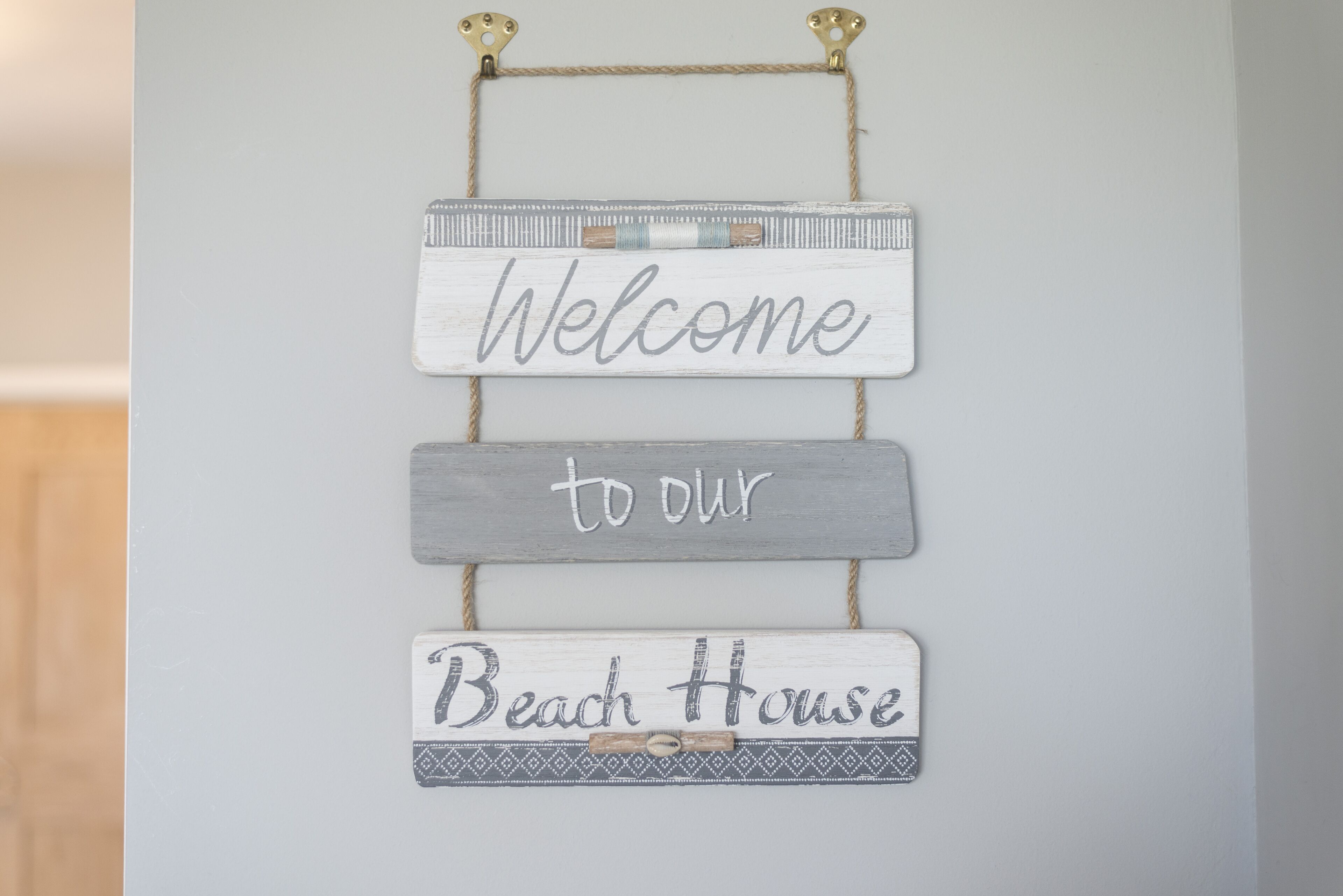 A wall-mounted sign with the words "Welcome to our Beach House."