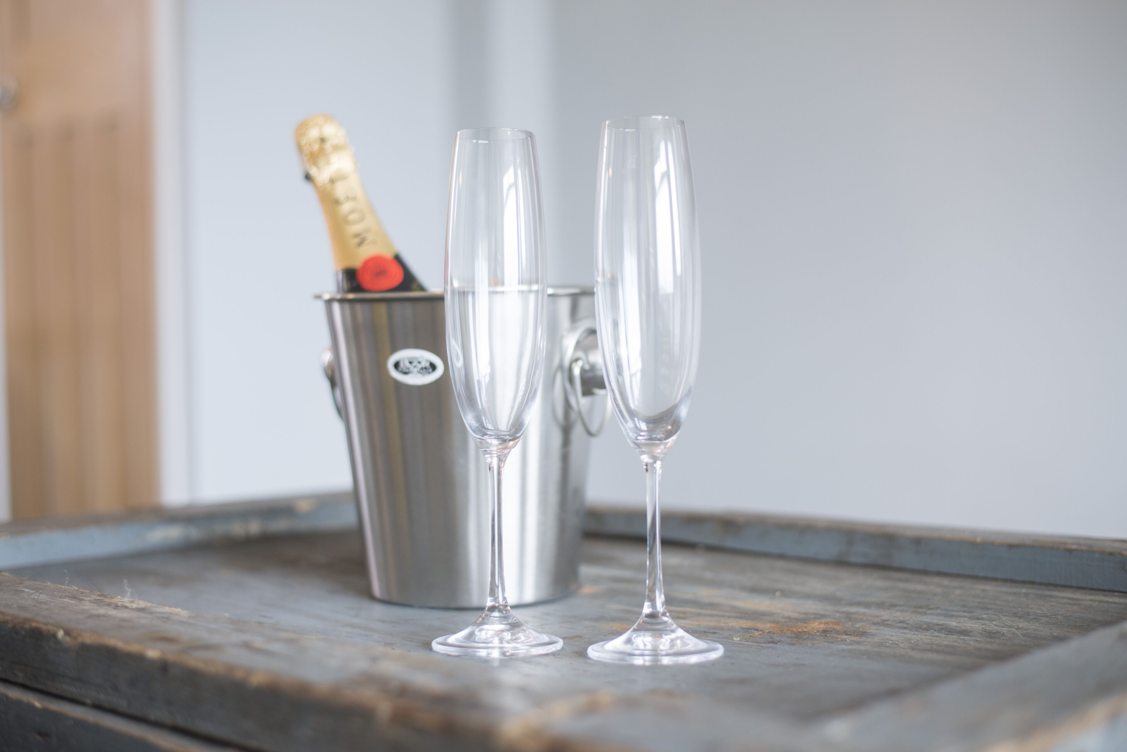 Un seau en métal contenant deux coupes à champagne vides et une bouteille de champagne.