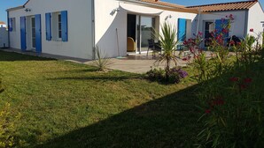 A modern house with a white exterior, blue shutters, and a tiled roof. - House the air of the wind (Saint-Denis-d'Oléron)