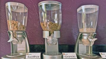 Three coffee grinders labeled Sucrinol, Zelevra, and Granola, with a purple wall in the background.