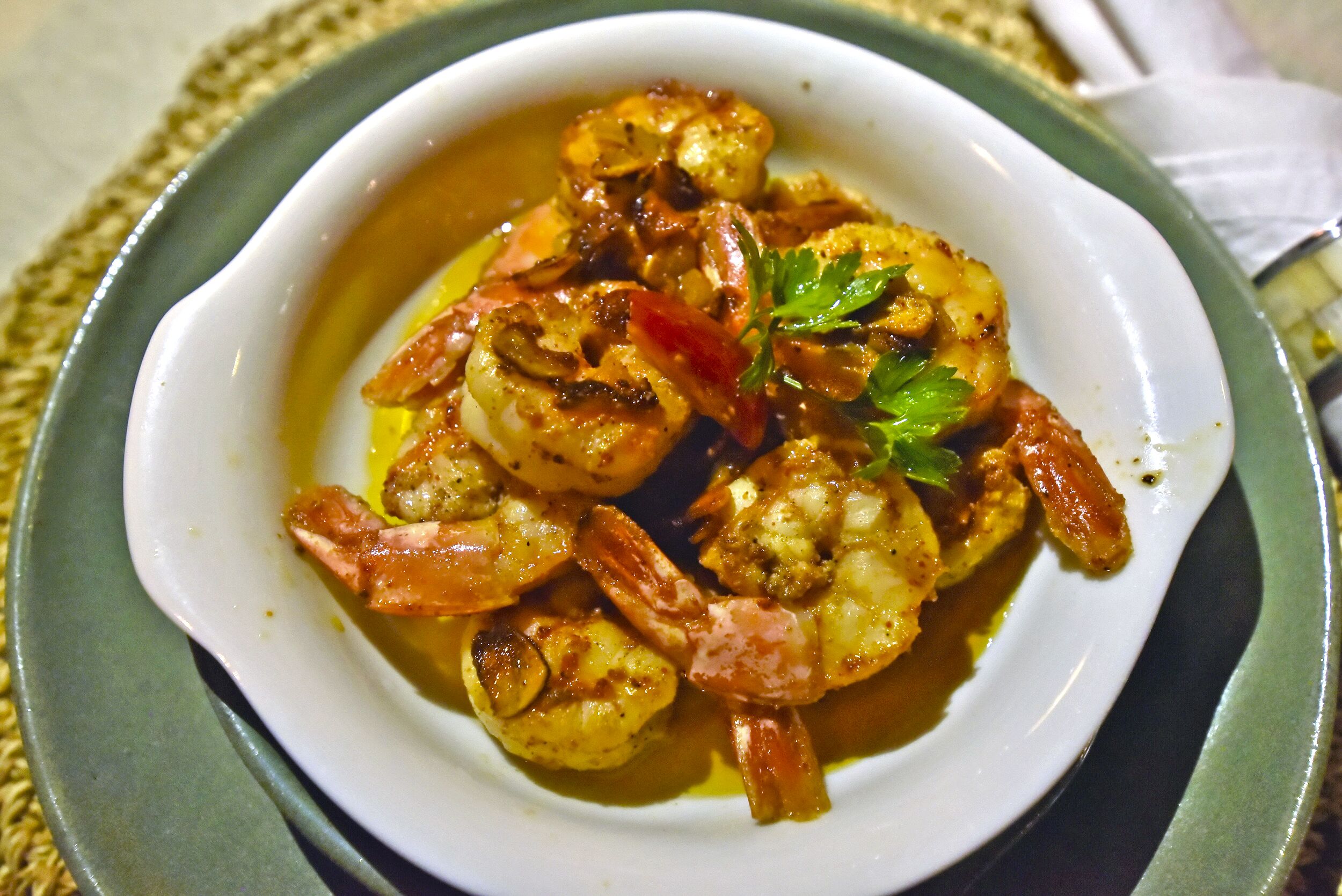 A bowl of shrimp with vegetables and herbs.