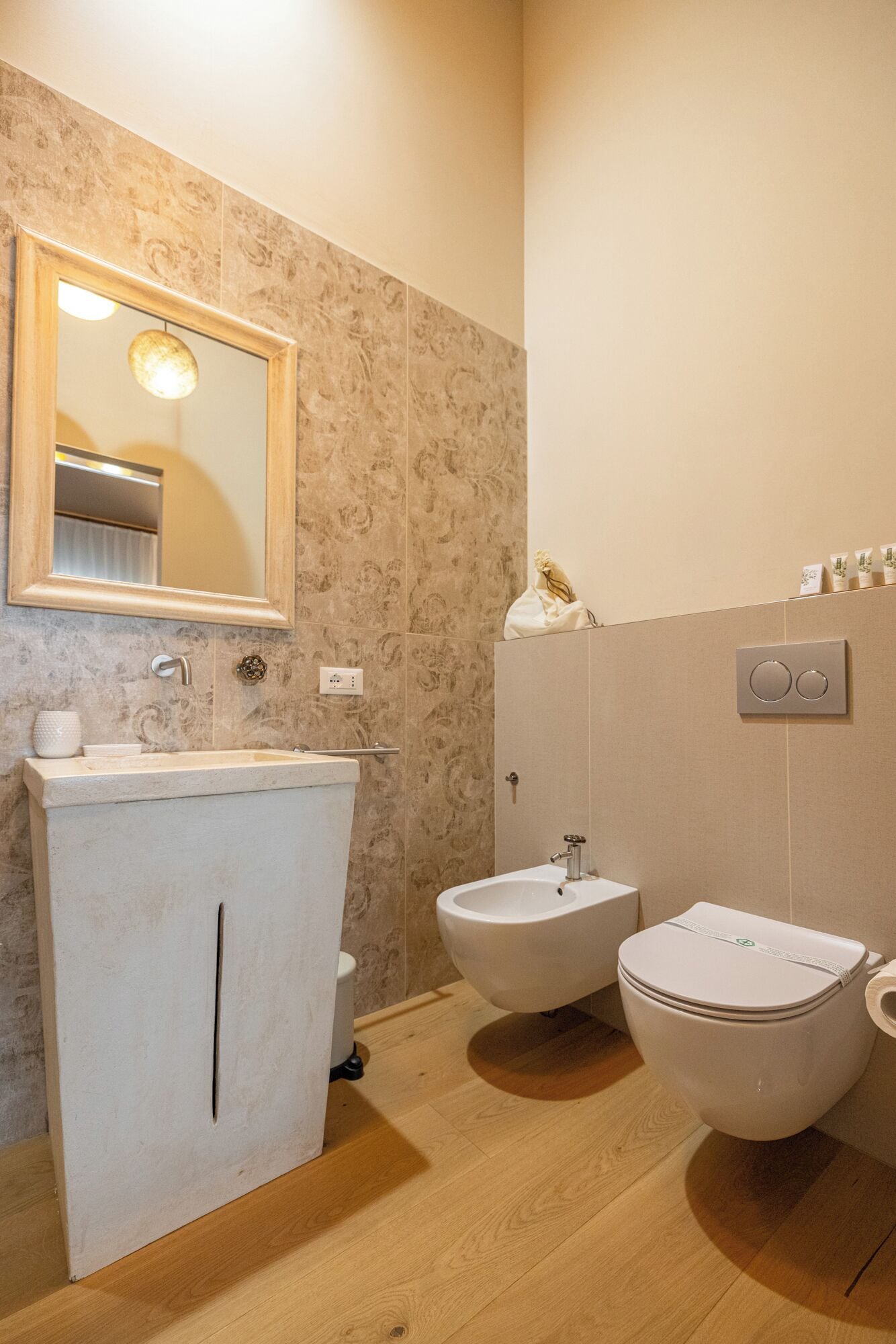 Ein Badezimmer mit Waschbecken, Bidet, Toilette und Spiegel.