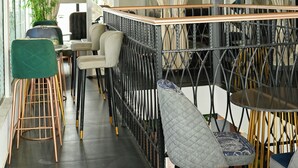 Un intérieur moderne avec un espace bar, des sièges et un éclairage décoratif.