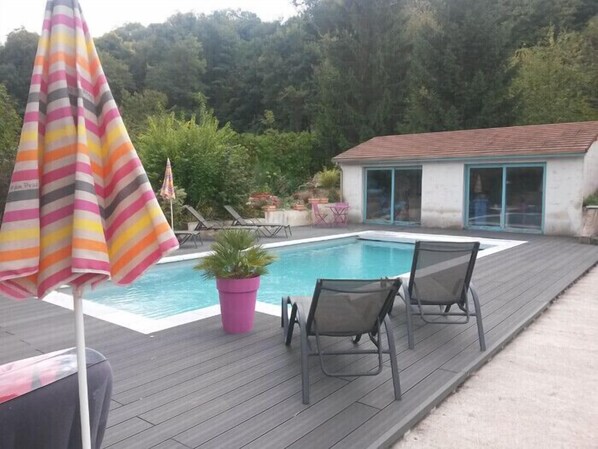 Una piscina al aire libre de temporada, tumbonas
