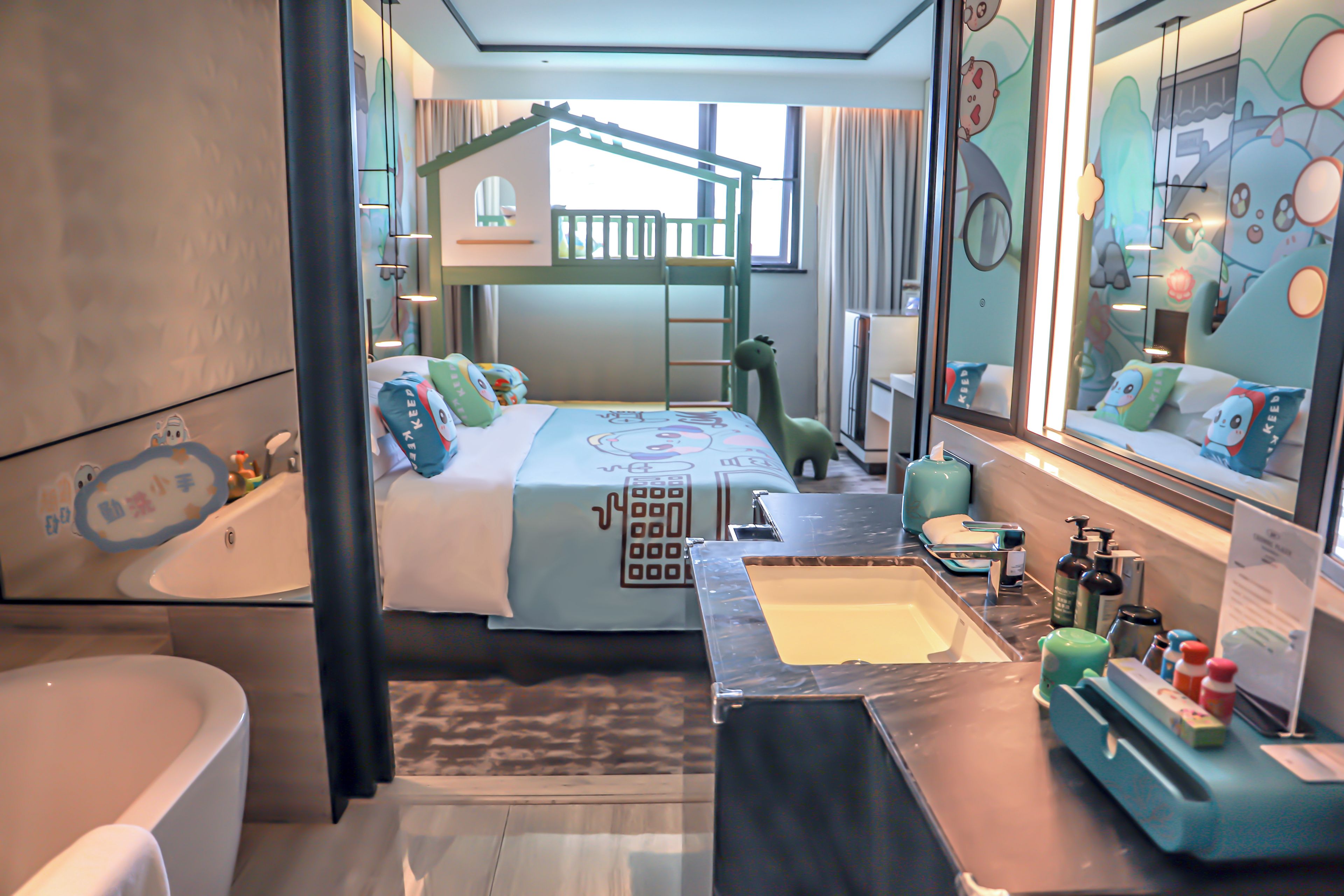 A hotel room with a bunk bed, a bathroom with a bathtub, and a vanity with toiletries.