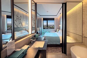 A modern hotel room with a large bed, a sitting area with a view, a bathroom with a bathtub, and a large window. - Crowne Plaza Wuzhen by IHG (Jiaxing)