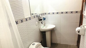 A small bathroom with a toilet, sink, and a towel rack.