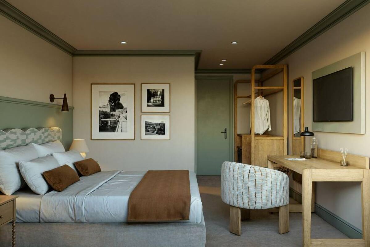 Un dormitorio con una cama, un escritorio, una silla y tres cuadros en la pared.