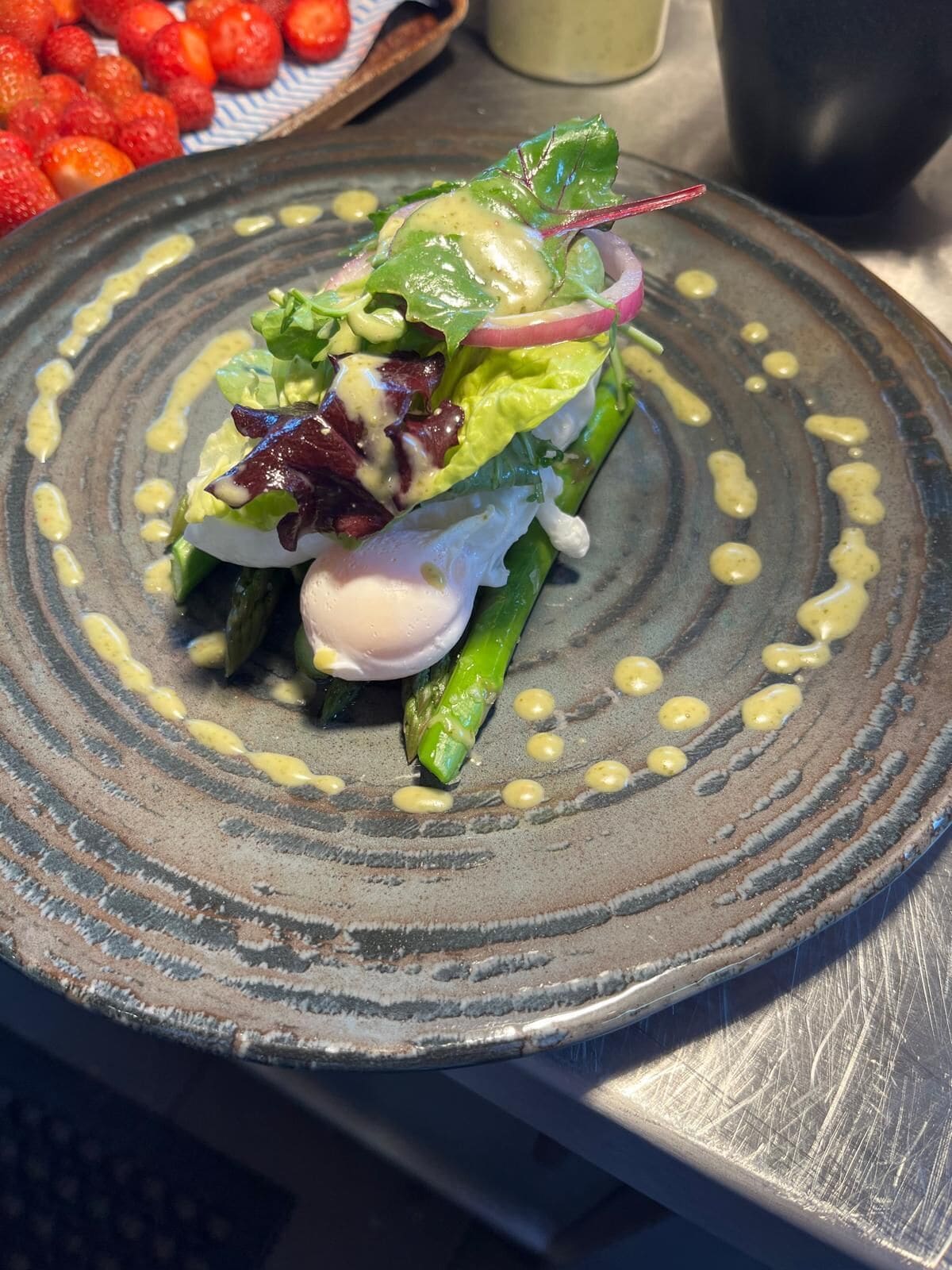 Un plato de comida con una variedad de verduras y un huevo escalfado, servido en un plato con textura.