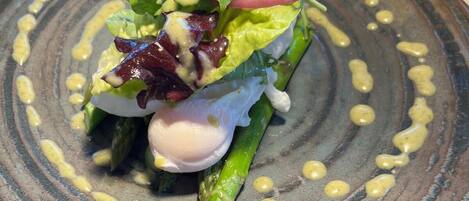 Un plato de comida con una variedad de verduras y un huevo escalfado, servido en un plato con textura.
