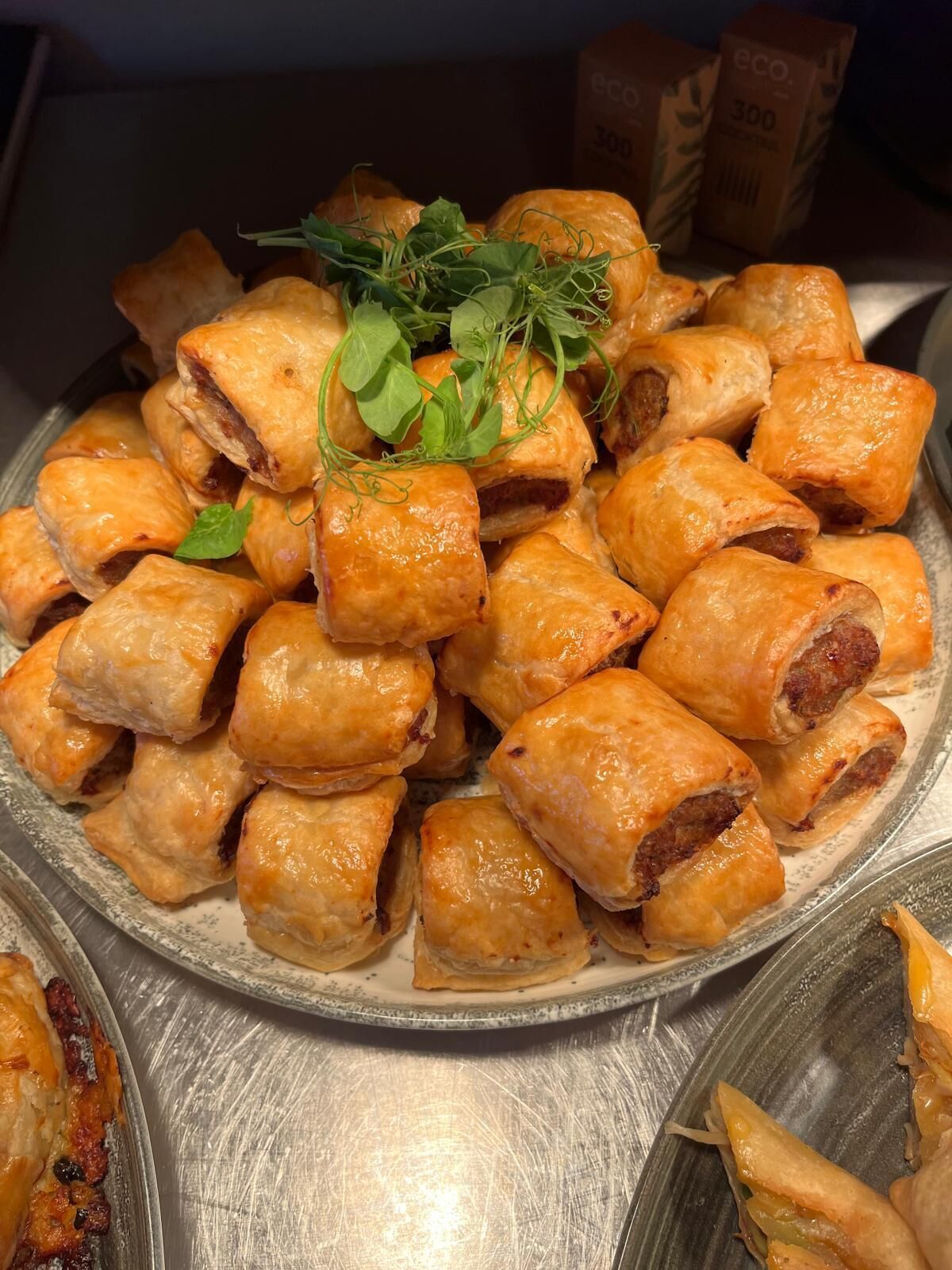 A plate of golden-brown pastries garnished with fresh greens, likely served as a snack or appetizer.