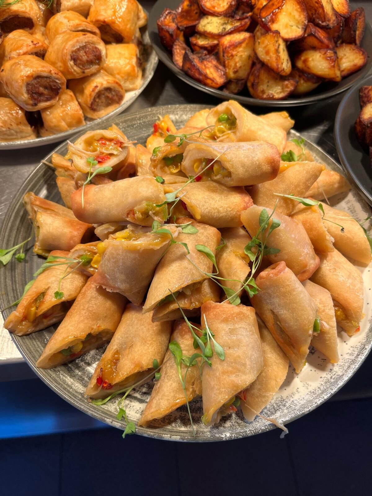 A plate of spring rolls garnished with microgreens.