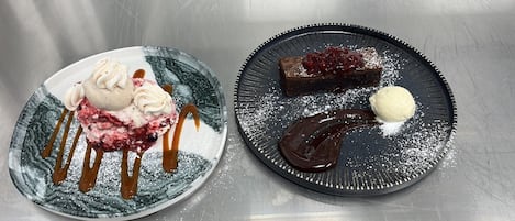 Two plates of dessert with caramel and chocolate sauce, one with a scoop of ice cream.