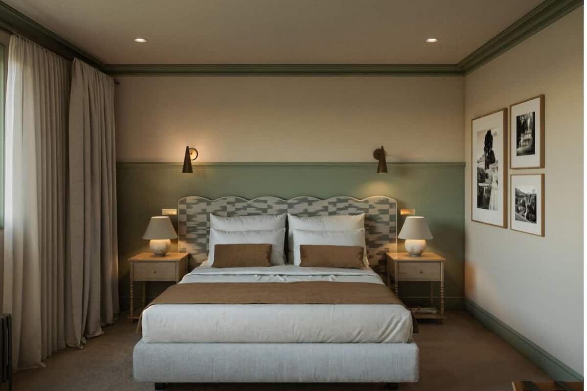Una habitación de hotel con una cama grande, dos mesitas de noche con lámparas, un cabecero con estampado geométrico y tres cuadros en la pared.