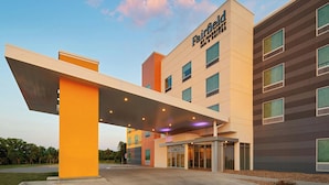 Un hotel moderno con techo plano, ventanas amplias y una zona de entrada cubierta.