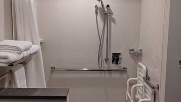Une salle de bain moderne équipée d’une douche, de toilettes et d’un lavabo.