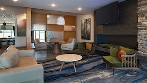 Una sala de estar moderna con un sofá, sillones, una mesa de centro y una chimenea.