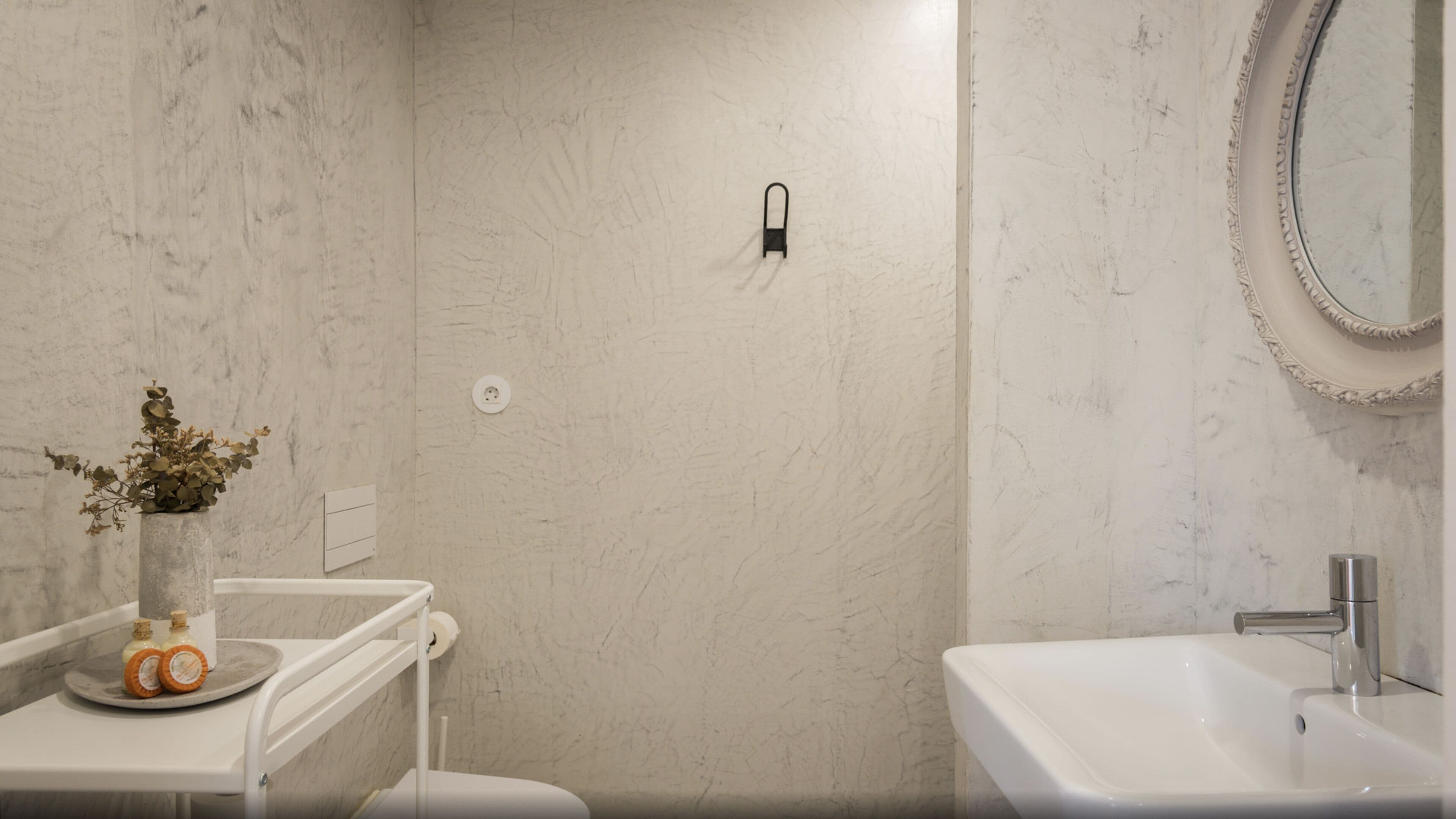 A bathroom with a white sink, a mirror, and a shower area.