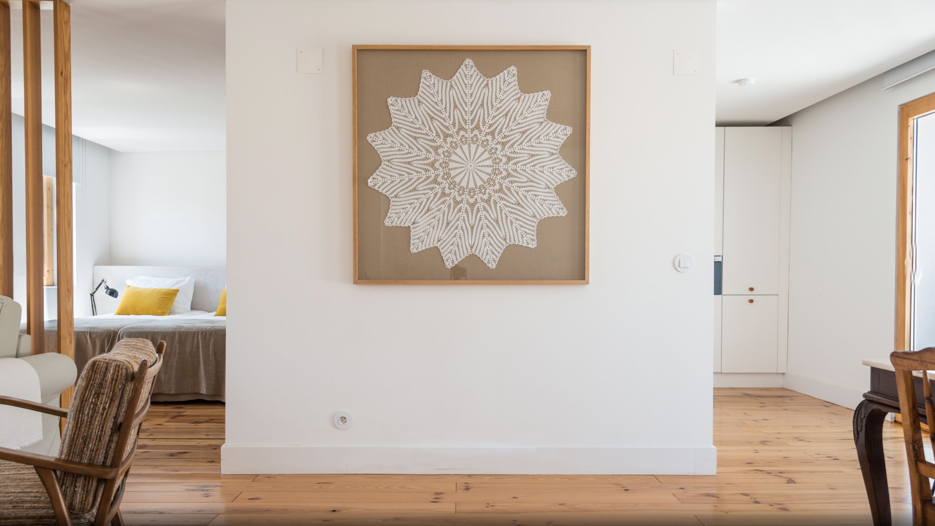 A modern living room with a large, intricate white wall art piece.