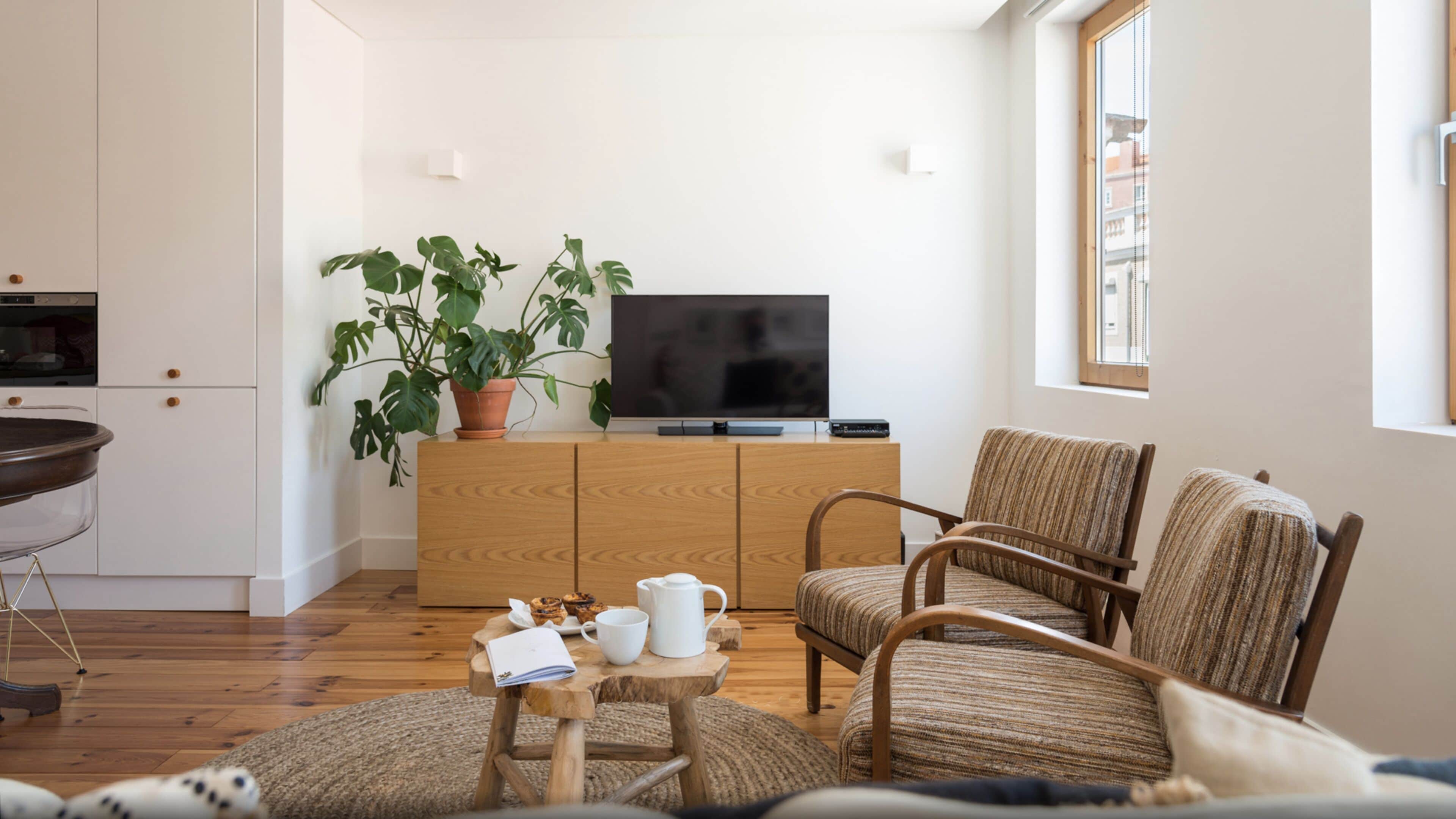 Una sala de estar moderna con un mueble de madera, un televisor y una planta en maceta.