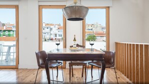 A dining area with a table, chairs, and a bottle of wine.