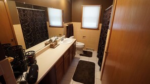Ein Badezimmer mit Waschbecken, Toilette und Duschbereich.