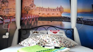 A bed with a canopy, a pillow with a mustache design, and a pillow with a red lips design. - Hostel Charme da Graça (Lisbon)