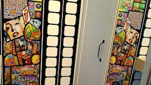 A room with a colorful, artistic door design featuring various pop art and graffiti elements. - Hostel Charme da Graça (Lisbon)