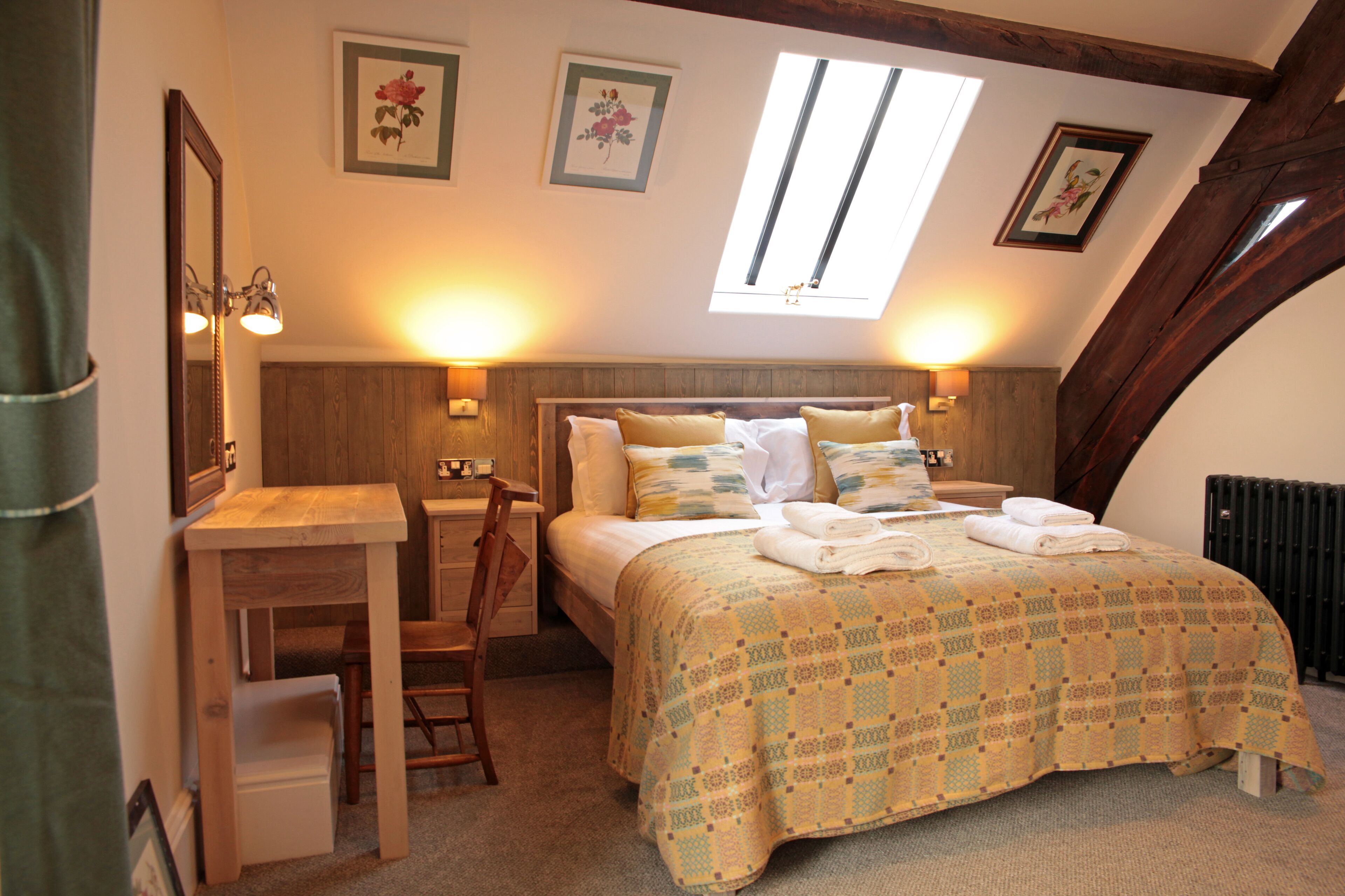 A bedroom with a bed, a desk, a chair, and a window.
