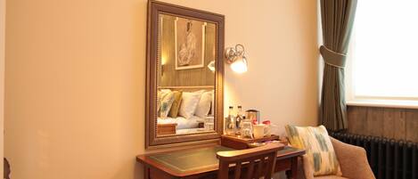 Ein Zimmer mit einem Holztisch, einem Stuhl, einem Spiegel, einer Lampe und einer Heizung.