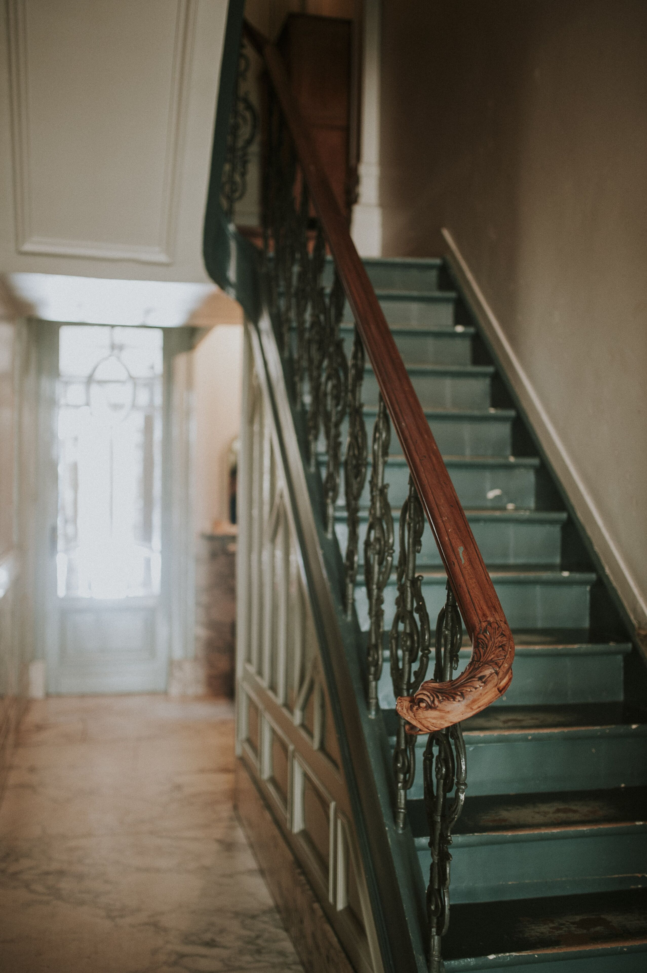 Una scala con ringhiere in metallo decorate e una balaustra in legno.