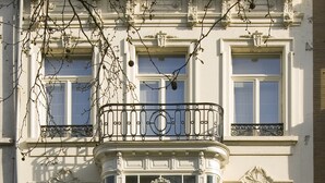 A building with a bay window, ornate balconies, and a large door. - Boulevard Leopold Rooms & Suites (Antwerp)