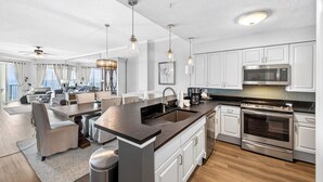 Una cocina moderna con una isla central, electrodomésticos de acero inoxidable y un comedor con vistas.