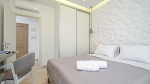 A hotel room with a bed, a desk, and a chair. - Elegant Apartments (Naxos)