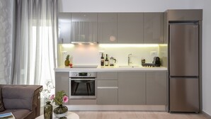 A modern kitchen with stainless steel appliances, a built-in oven, and a double-door refrigerator. - Elegant Apartments (Naxos)