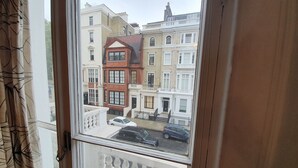 Une vue depuis une fenêtre d’une rangée de maisons mitoyennes, dont certaines ont un balcon.