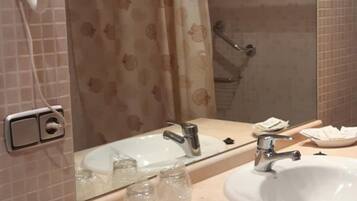 Une salle de bain avec un double vasque, un grand miroir et un espace douche.