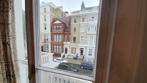 A view from a window of a row of terraced houses with a balcony. - Studio Apartment in South Kensington 8 (London)